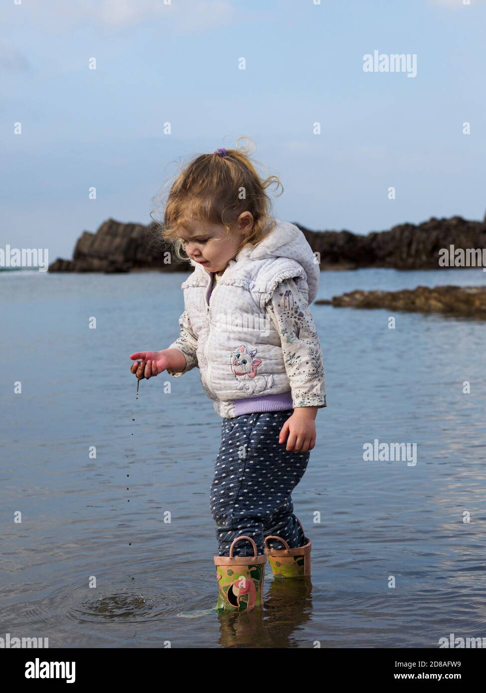 Young child playing in the sea, Cornwall, UK Stock Photo