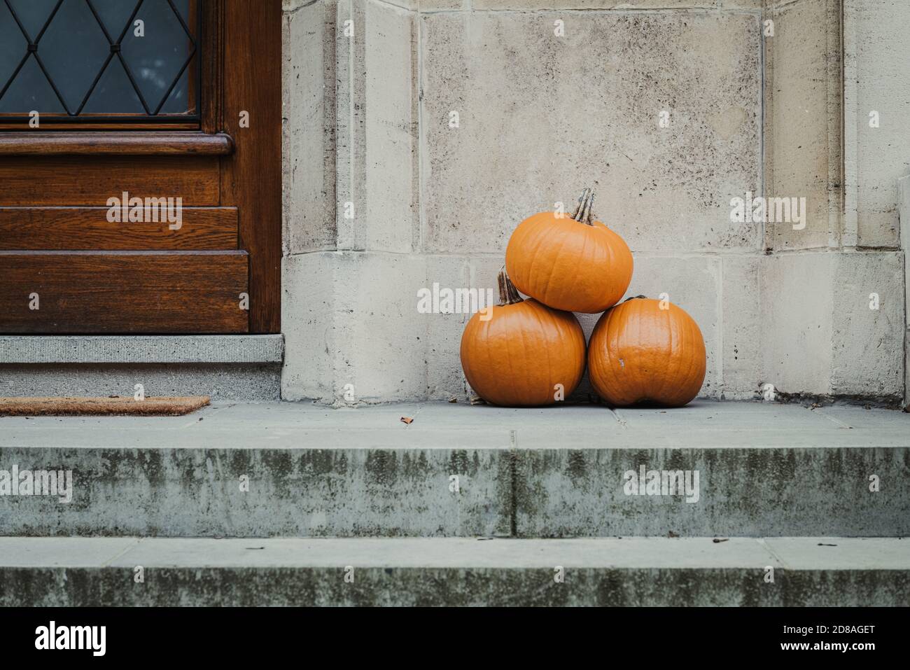 Three yellow pumpkin outside a house, for halloween Stock Photo - Alamy