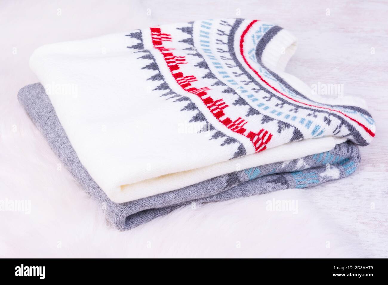 Warm winter knitted sweaters on white cozy background. Stock Photo