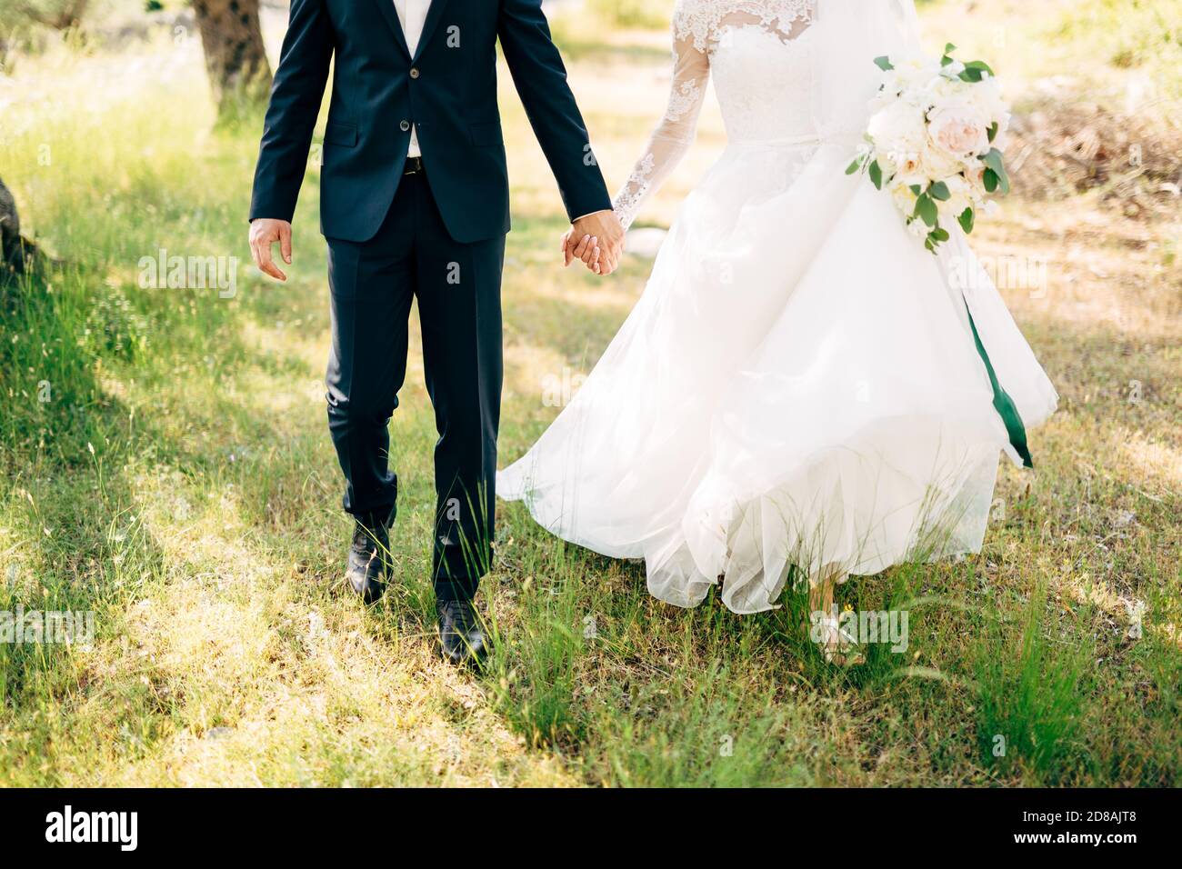 bride and groom walking together in olive grove and holding hands Stock ...