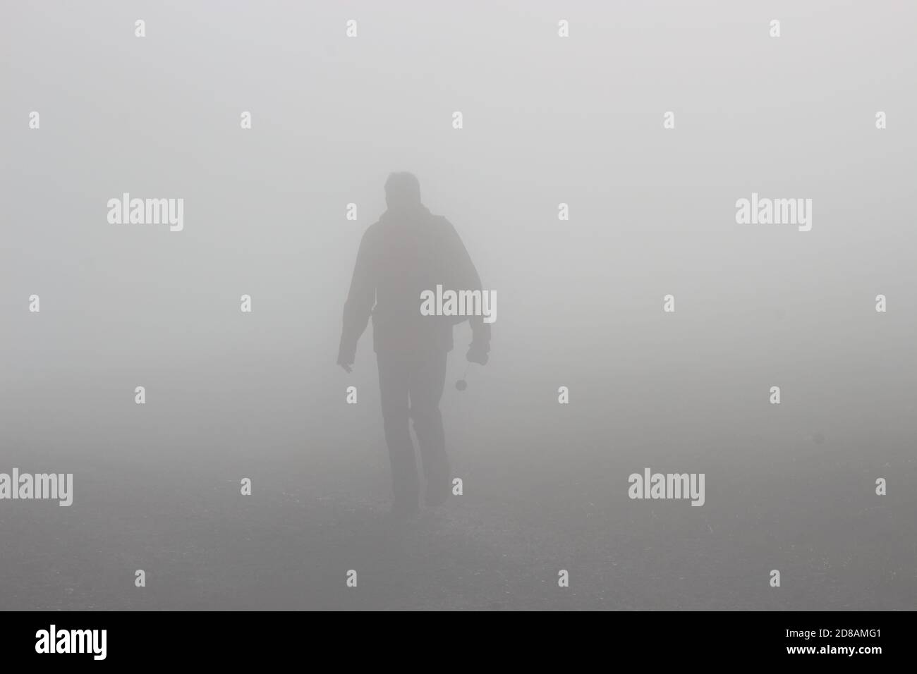A man walks up a hill in dense fog. On a mountain footpath, height approx. 1300 m.  Hinterstoder, Upper Austria, Europe. Stock Photo
