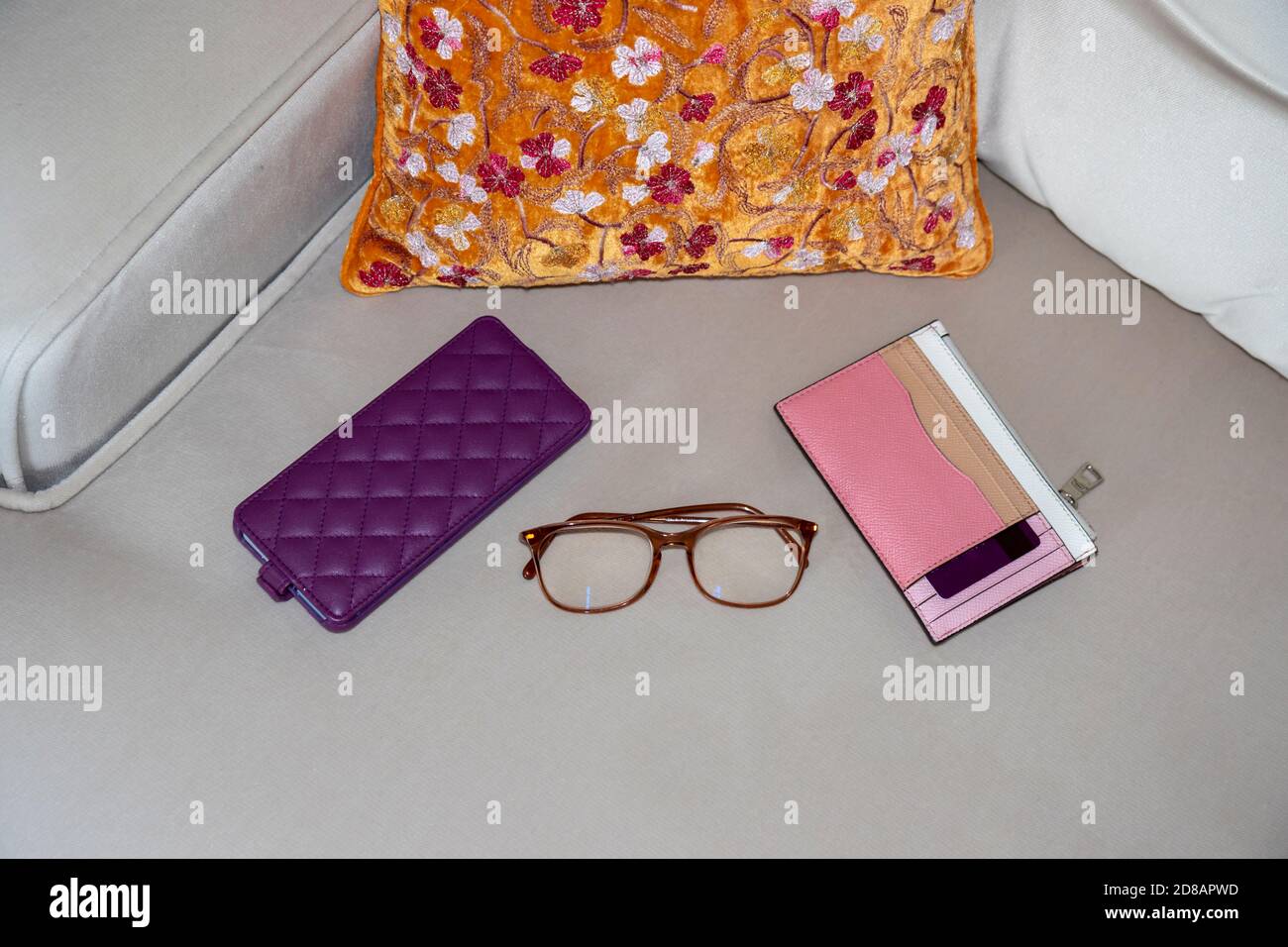 Mobile phone smartphone, credit card wallet and reading glasses isolated on sofa. Concept online shopping from home with luxury and comfort Stock Photo