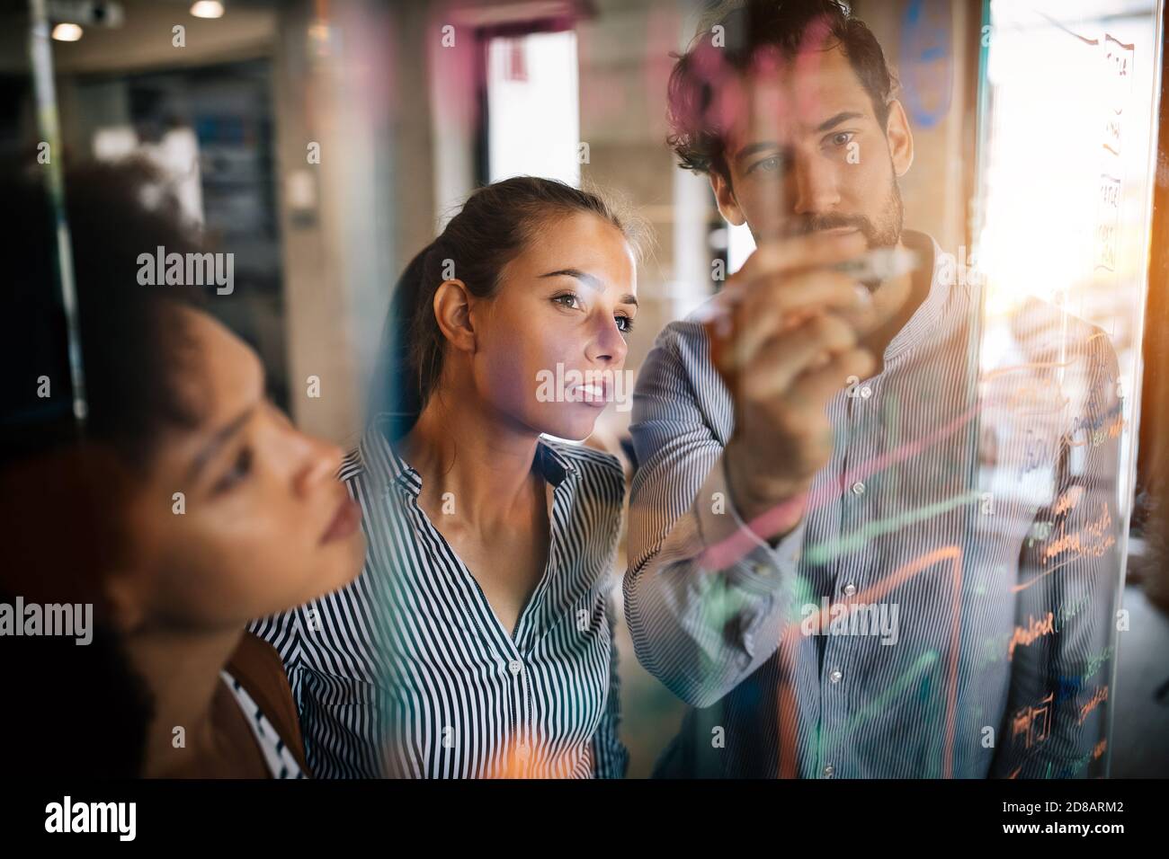 Programmers cooperating at IT company developing apps Stock Photo