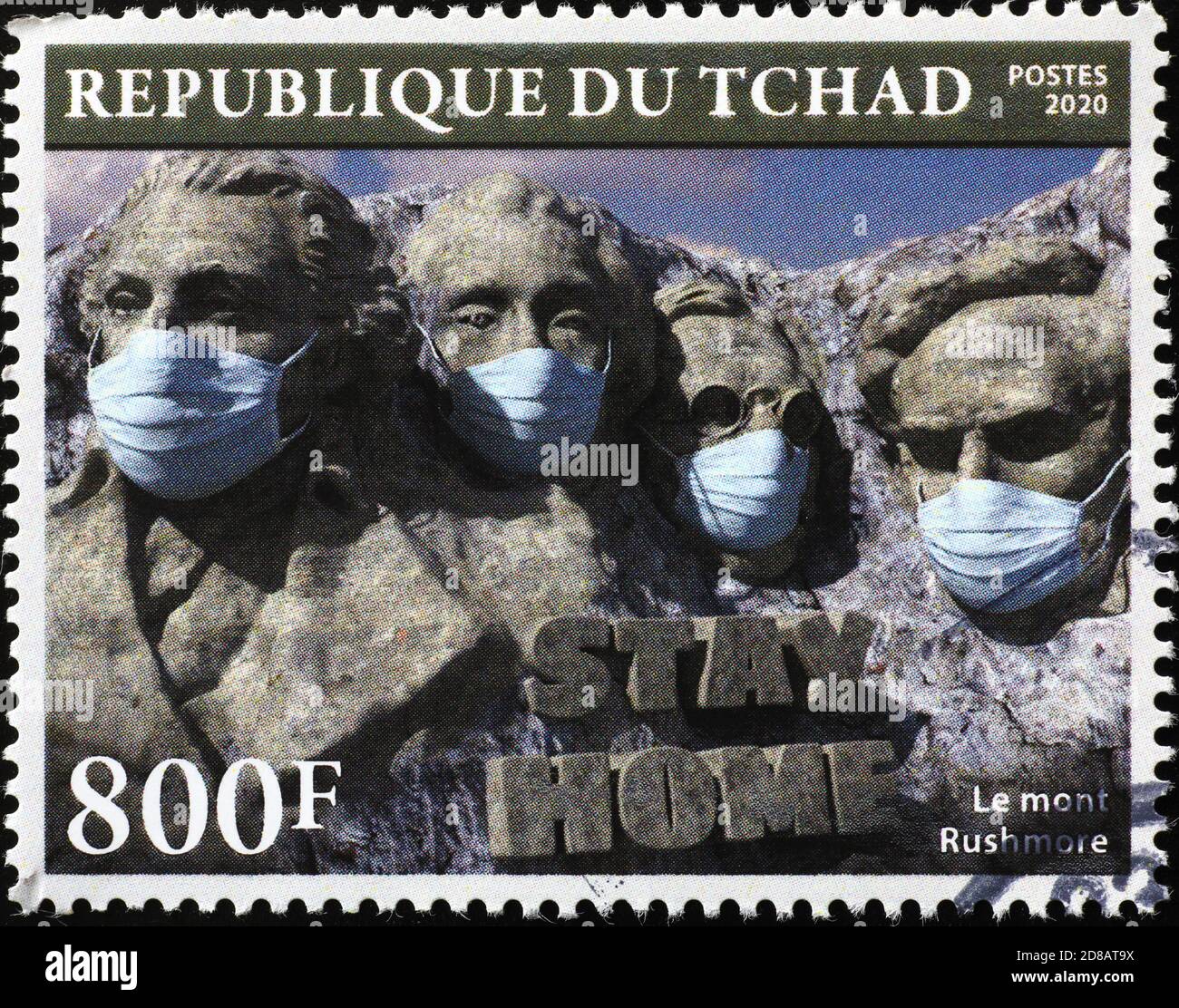 The presidents of Mount Rushmore with antivirus masks on stamp. Image of the statues wearing the mask. Stock Photo