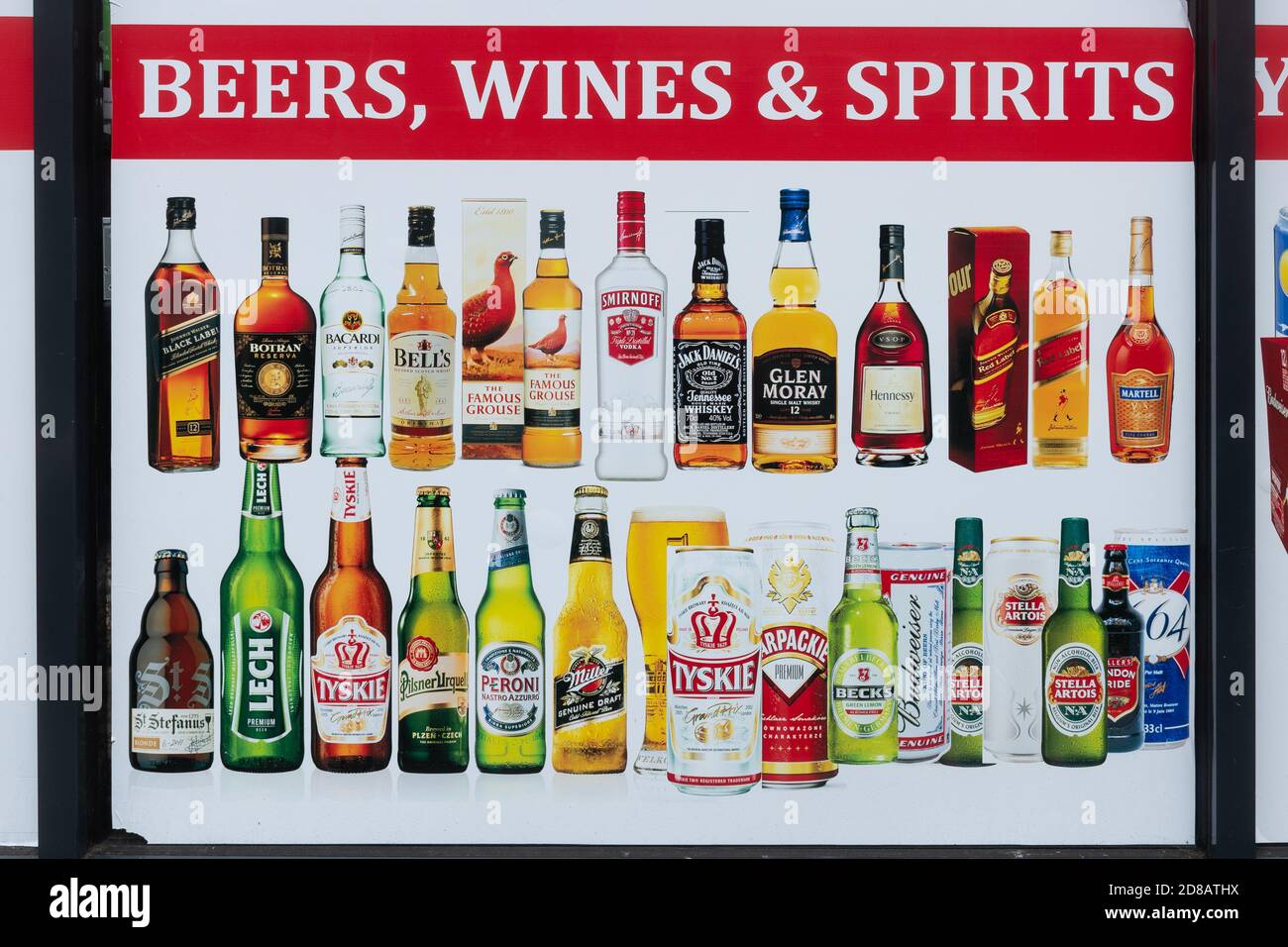 Advertising poster for beers, wines and spirits in the window of a convenience store, UK Stock Photo