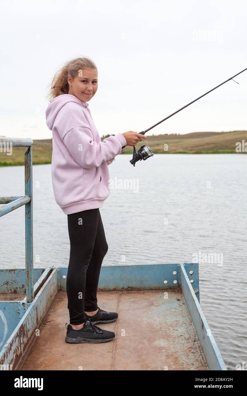 Pre-teen girl portrait with fish rod, female fisherman catching