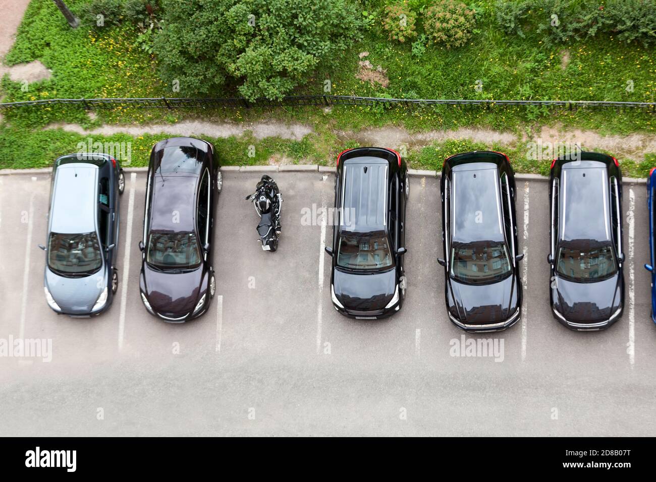 Line from parked cars and one motorcycle standing on a parking place