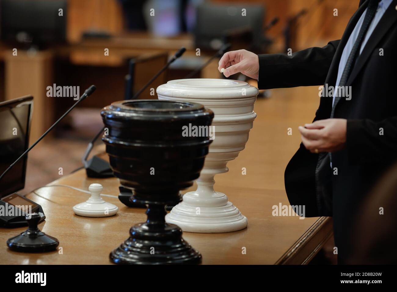 Bucharest, Romania - October 27, 2020: Details with Romanian MP casting a secret vote with black and white balls (Blackballing) in black and white urn Stock Photo