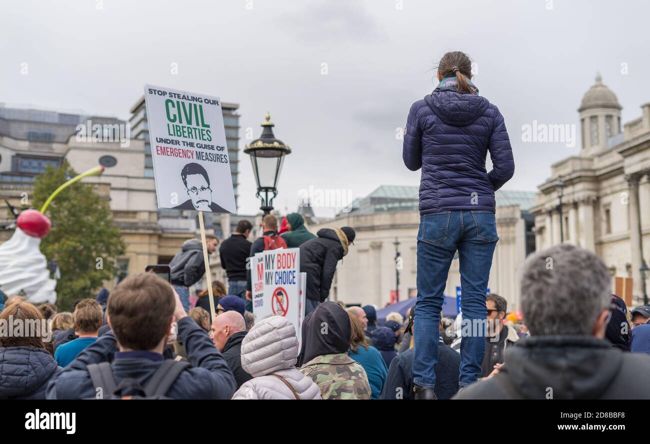 Anti covid-19 lockdown protest in Trafalgar Square. Focus on lady standing alone. London Stock Photo