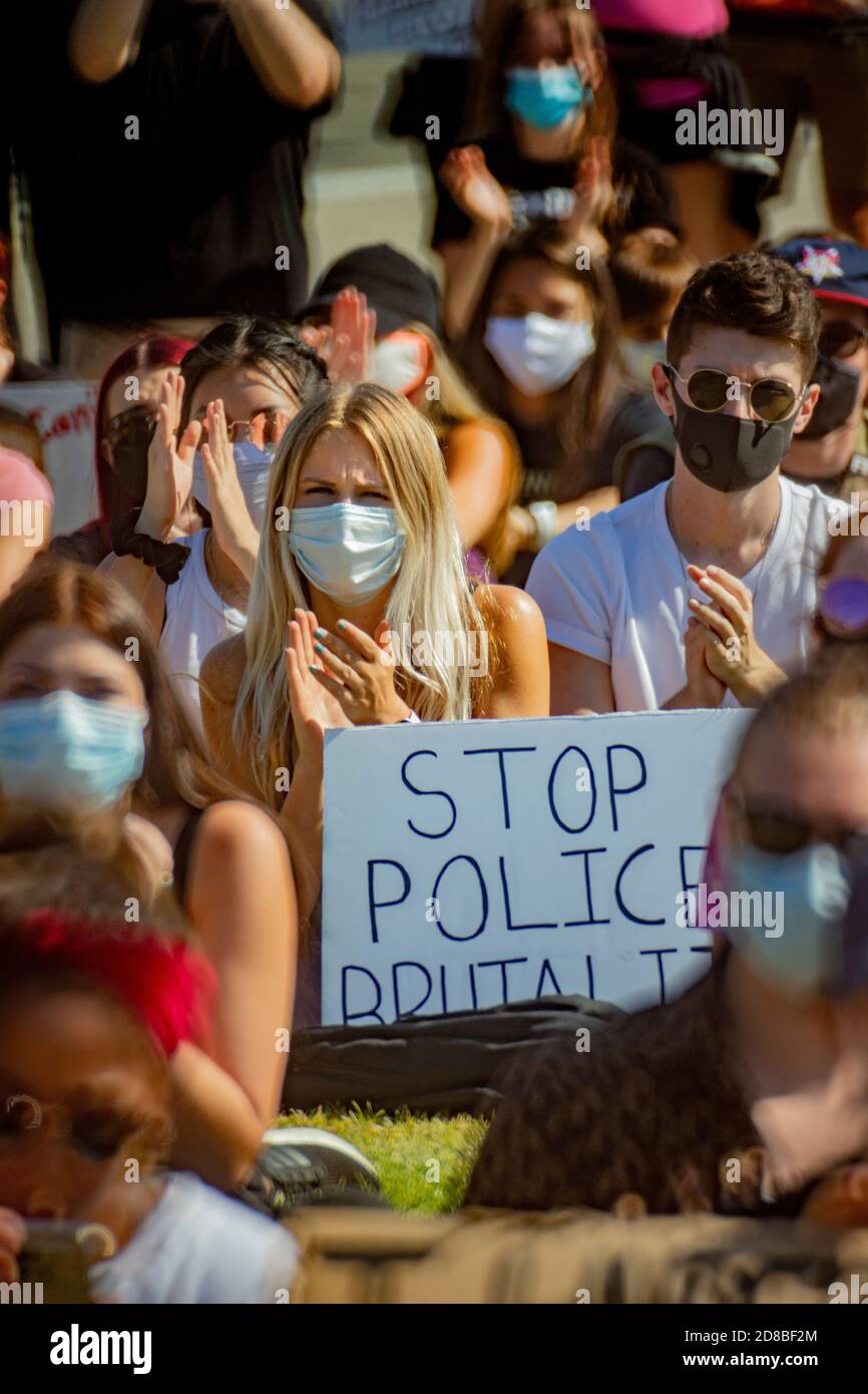 Wearing face masks due to coronavirus, a Black Lives Matter demonstration carries signs in Irvine, CA. Stock Photo