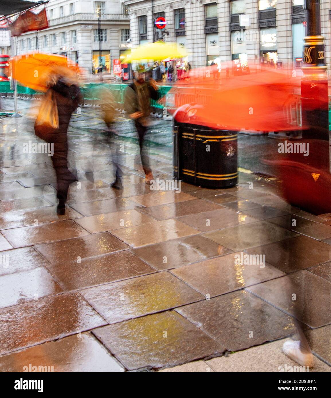 People walking in the rain along Piccadilly outside the Ritz and Green