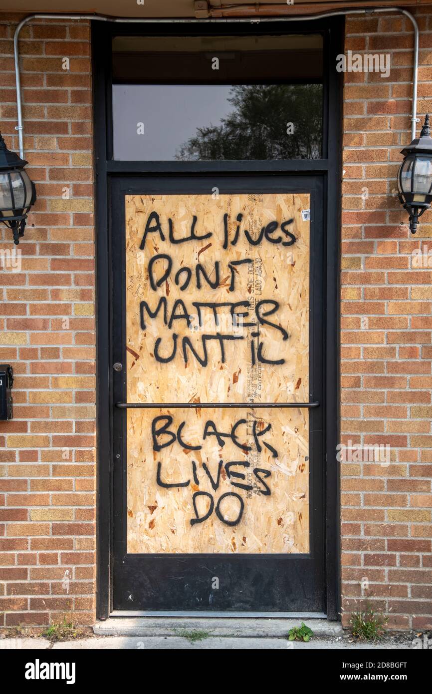 Minneapolis, MN.  Graffiti on boarded up business at George Floyd memorial site.  all lives don't matter sign on door. Stock Photo