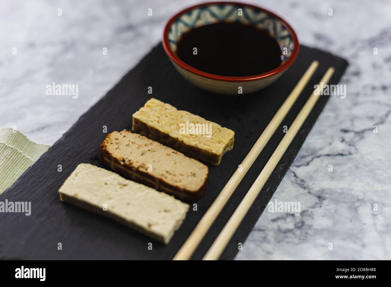 Table with different soy products. Tofu, tempeh, and smoked tofu with