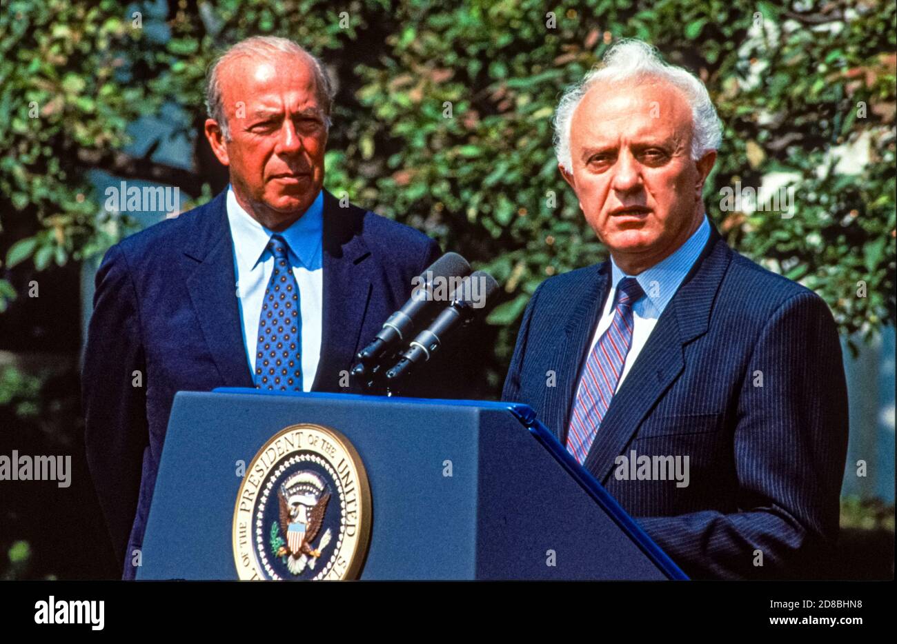 United Stares Secretary of State George P. Shultz, left, listens as ...