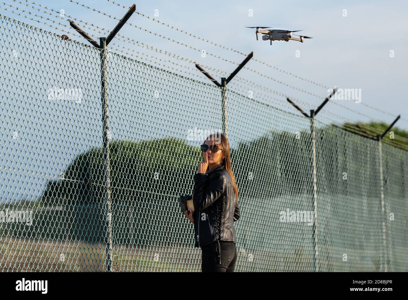 Woman flying drone in forbidden zone. Fly without a license. Fly drone near airport. Drone legislation.Drone as spy tool Stock Photo