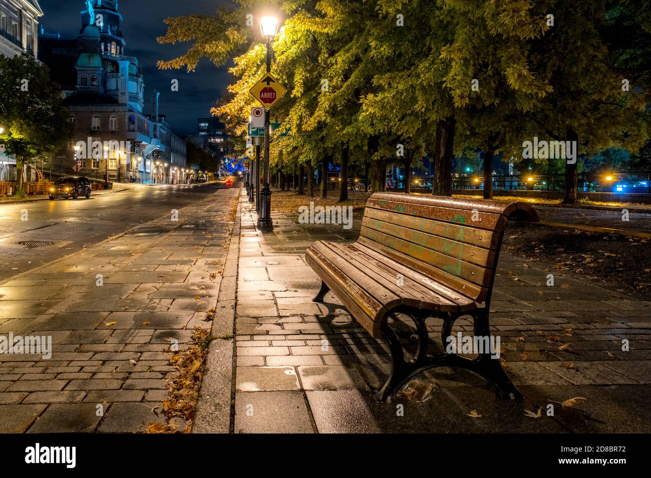 Banc sur la rue de la Commune, de nuit,  devant le marché Bonsecours à Montréal après la pluie. Stock Photo