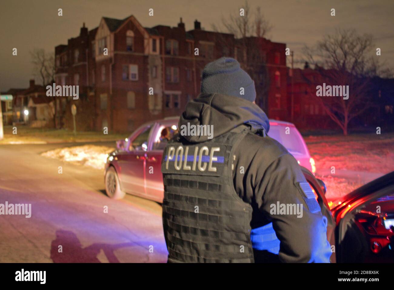 Detroit police officer checks a vehicle in the street at night, Detroit, Michigan, USA Stock Photo