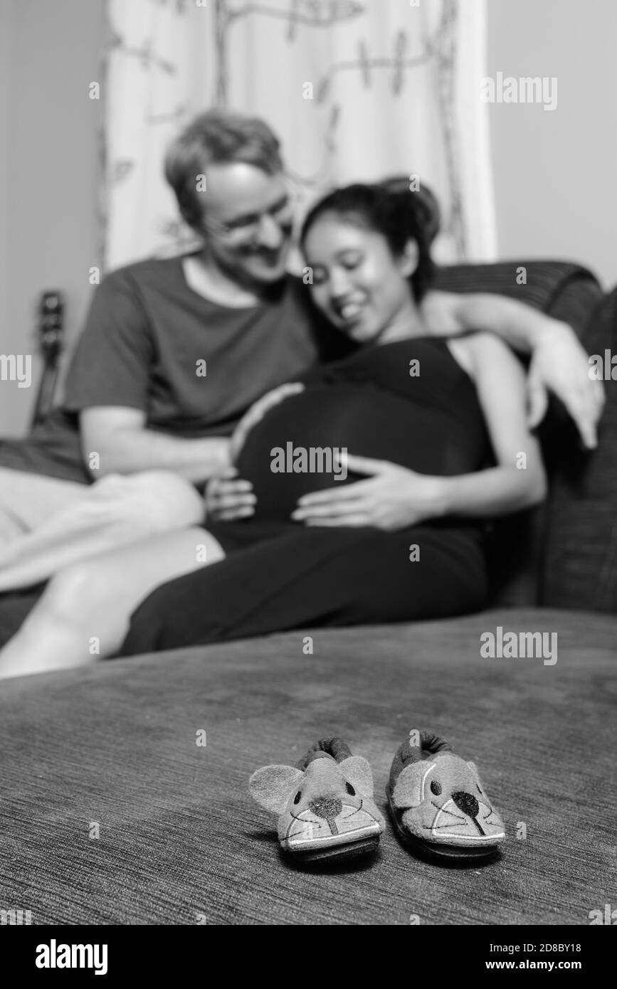 Multi ethnic couple married and in love in the living room Stock Photo