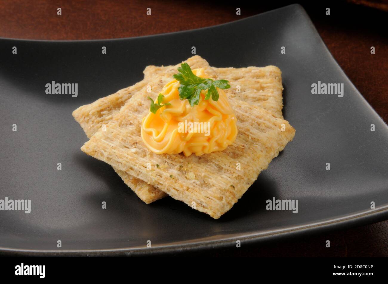 Cheddar cheese spread on whole wheat crackers Stock Photo Alamy