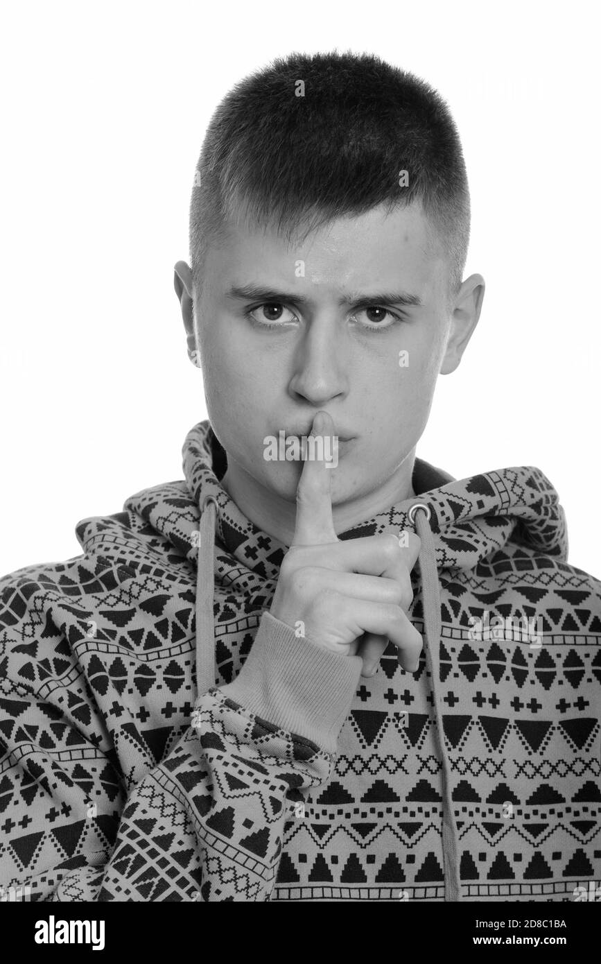 Face of young Caucasian man with finger on lips Stock Photo