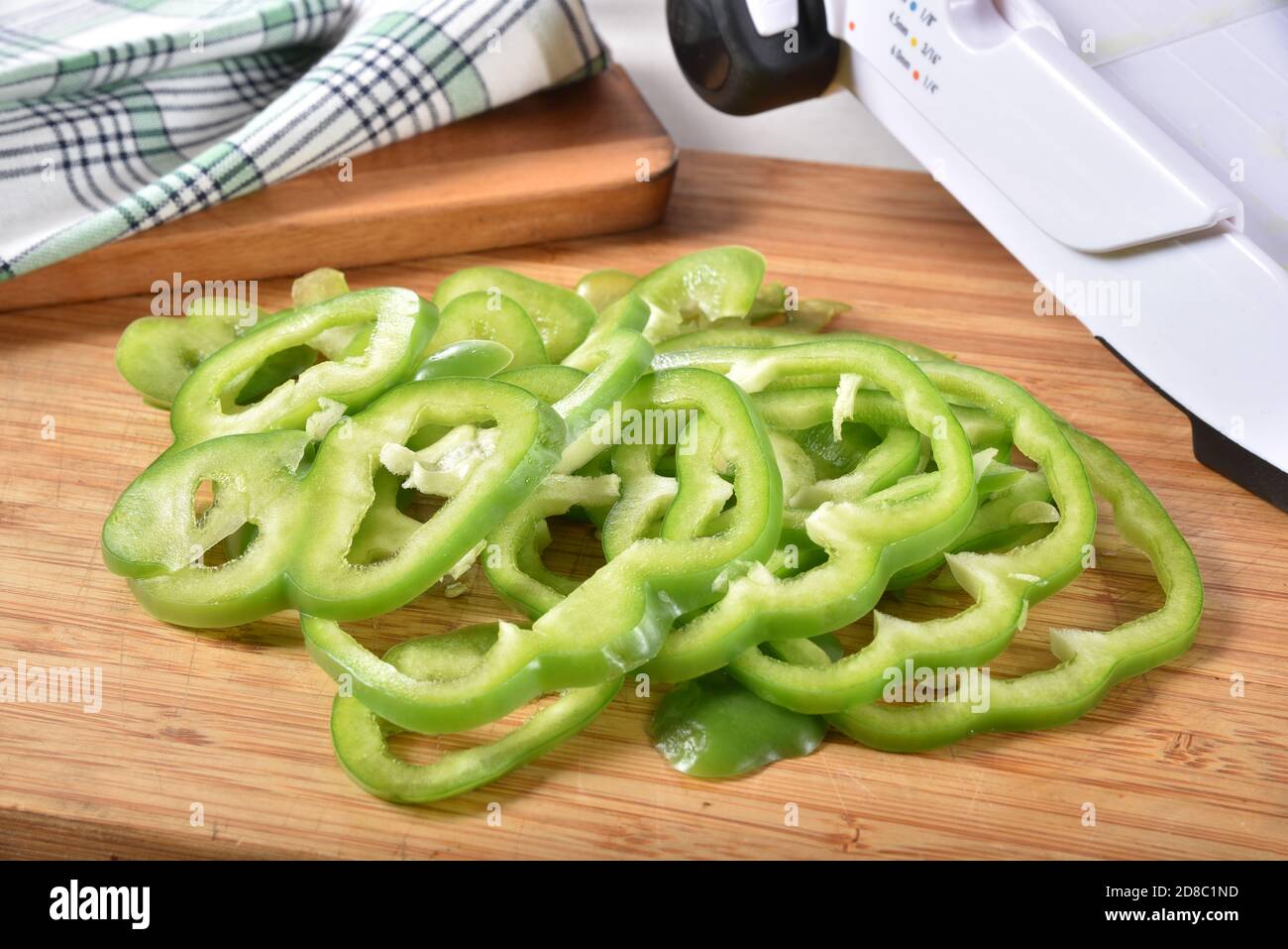 https://c8.alamy.com/comp/2D8C1ND/thin-sliced-green-bell-peppers-next-to-a-mandolin-on-a-cutting-board-2D8C1ND.jpg