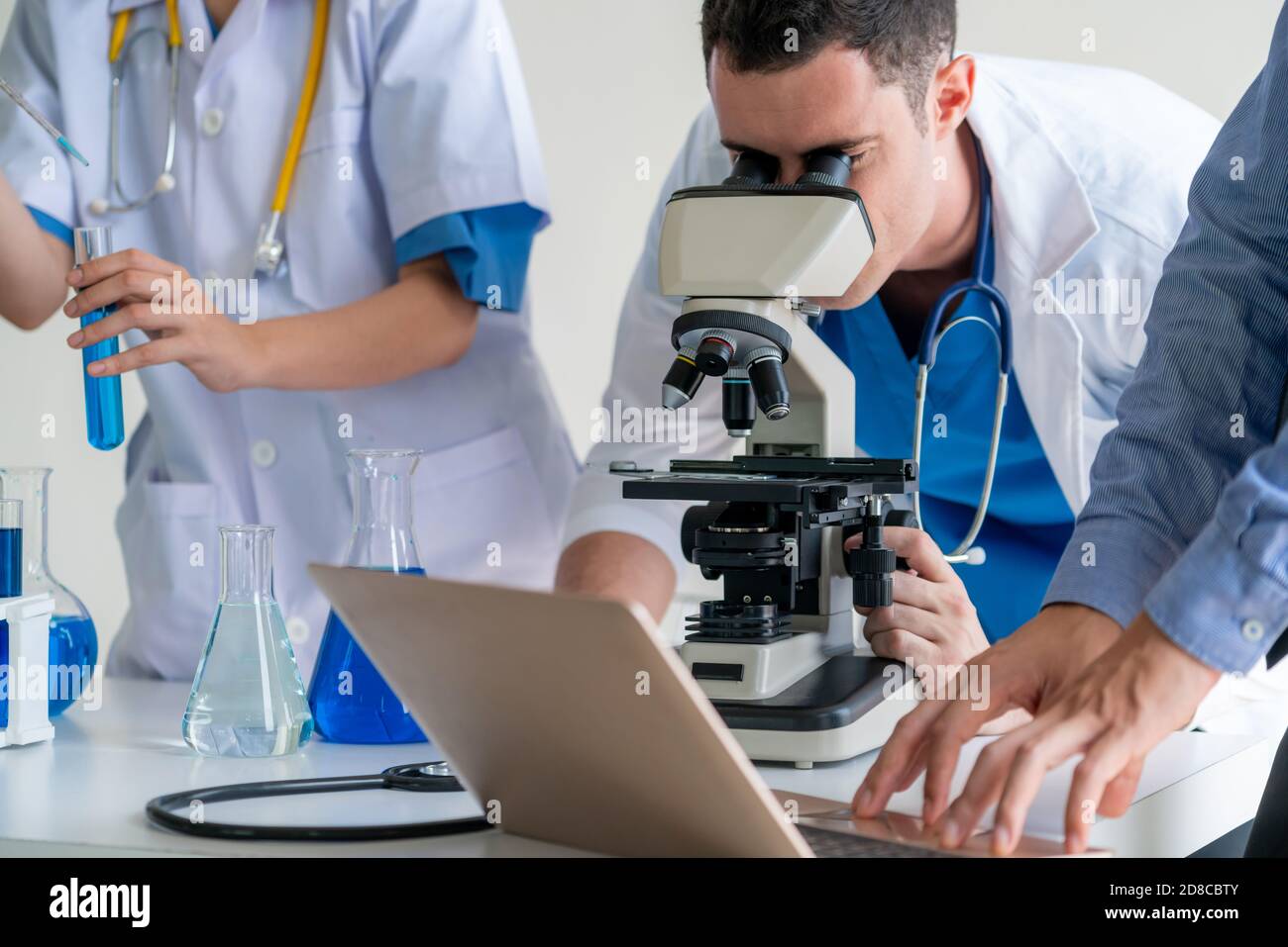 Group of scientists wearing lab coat working in laboratory while
