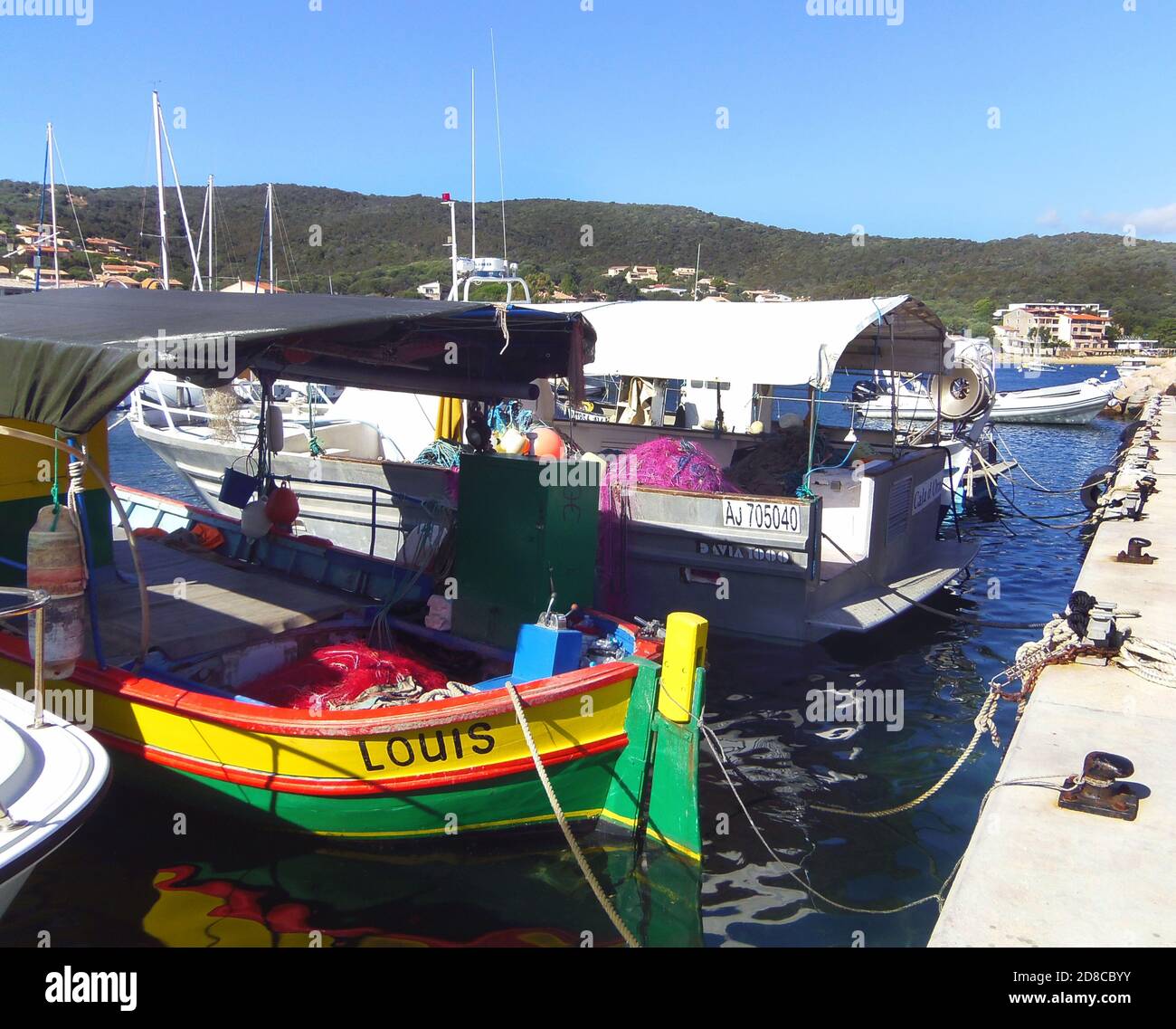 Brightly painted fishing boats anchored in the harbour of sleepy seaside village   Porto Pollo, Gulf of Valinco, Corsica France Stock Photo