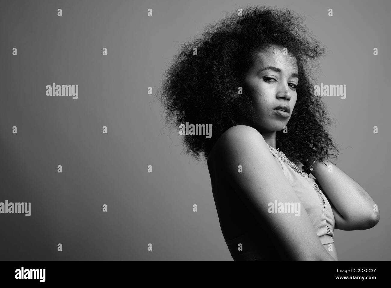 Young beautiful African woman against gray background Stock Photo