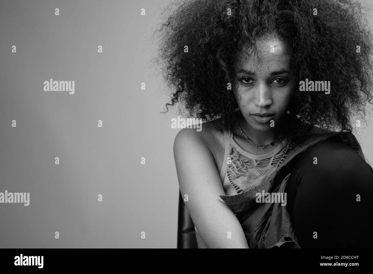 Young beautiful African woman against gray background Stock Photo