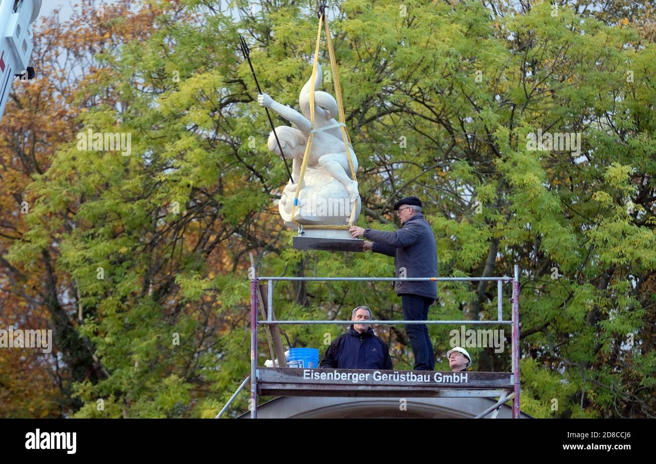 Leipzig, Germany. 29th Oct, 2020. The sculpture of a representation of  Poseidon is lifted with a crane onto the portal of the aquarium of the  Leipziger Zoss. The hollow sculpture of the