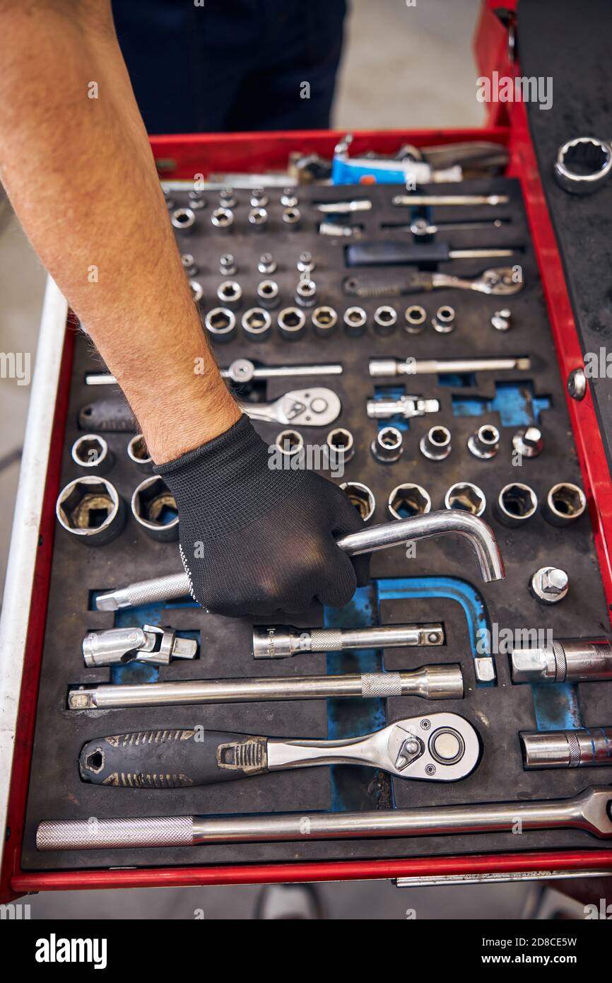 Auto mechanic grabbing curved rod wrench from vehicle tools box Stock Photo  - Alamy