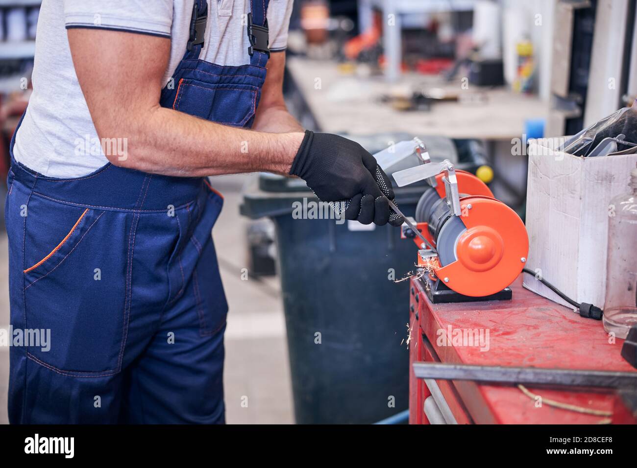 Male worker using grinding machine in garage Stock Photo