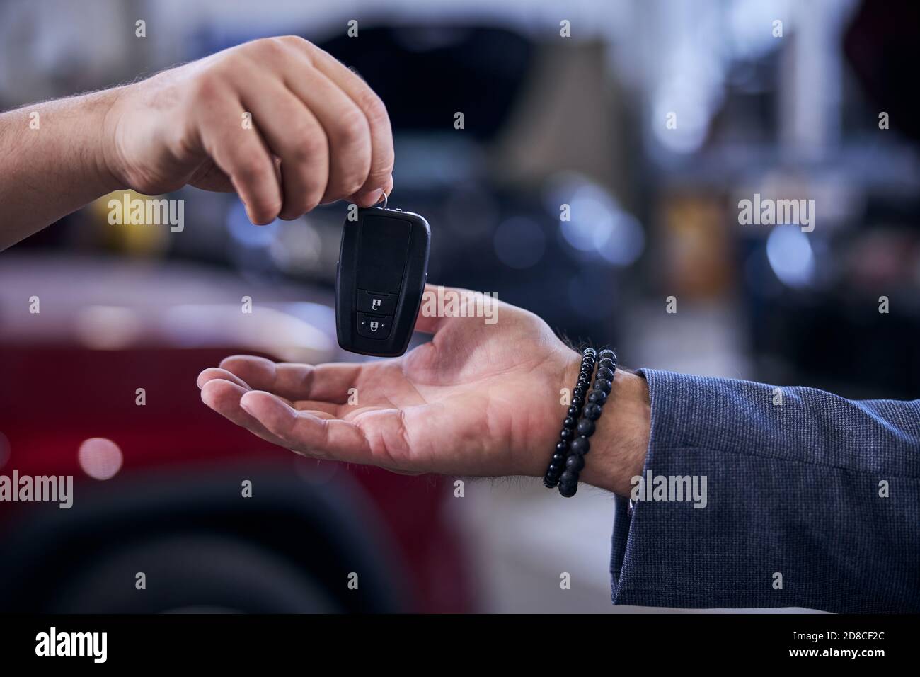 Mechanic handing man modern electronic car key Stock Photo Alamy