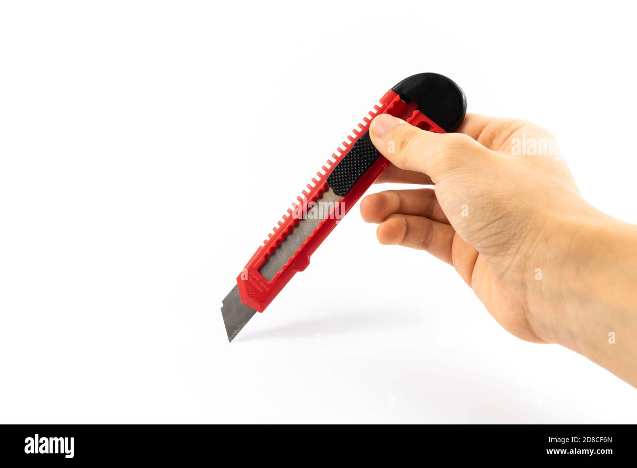 Stationery knife in hand of a man schoolboy on white isolated background Stock Photo