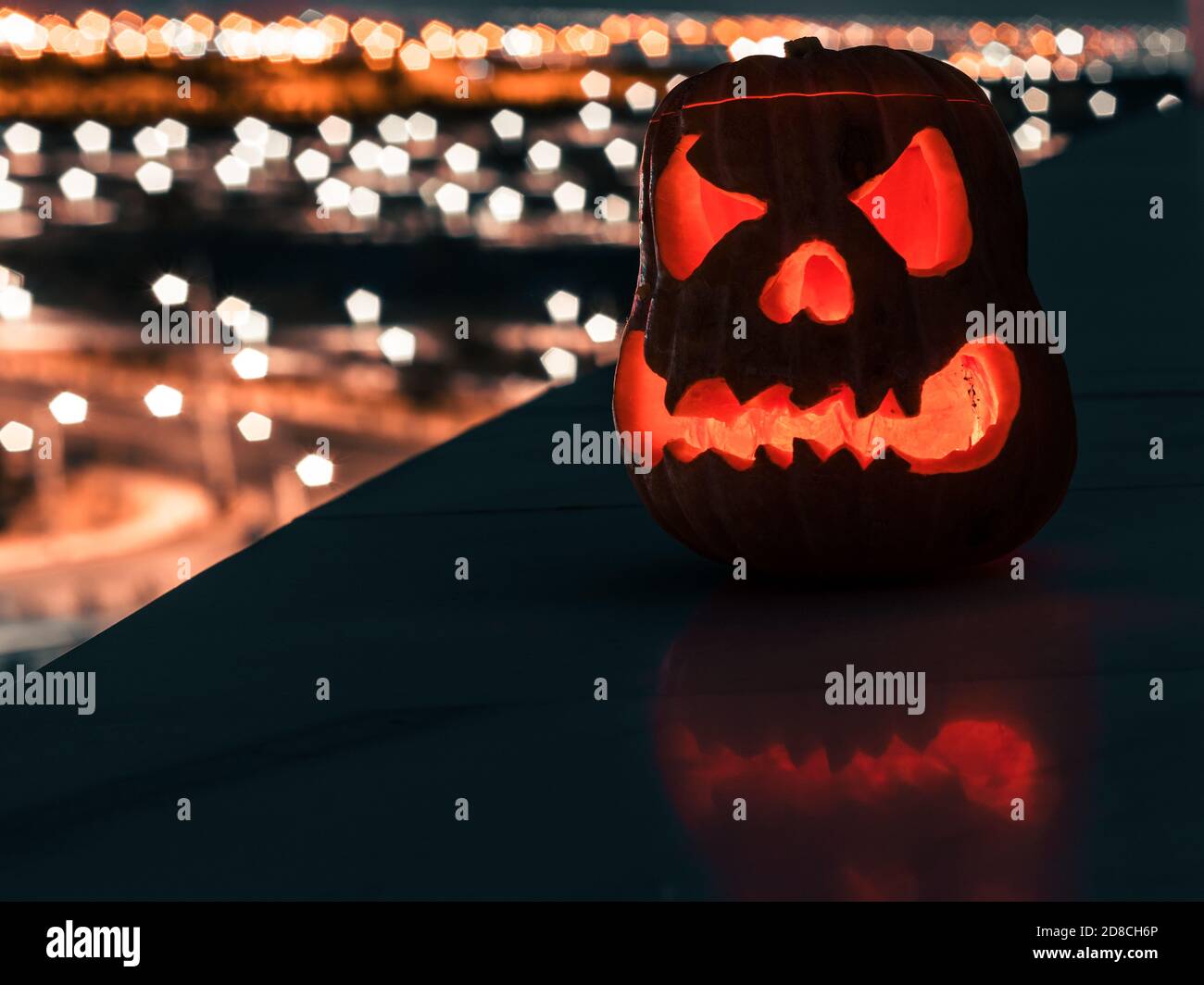 scary halloween pumpkin glowing at night on a balcony. Stock Photo