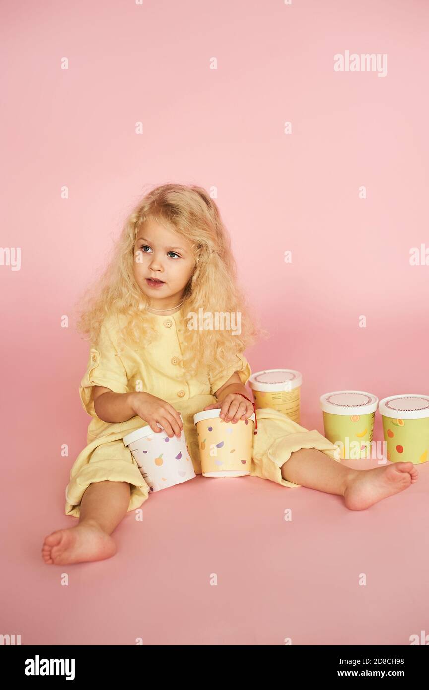 Cheerful little girl with colored paper trays Stock Photo Alamy