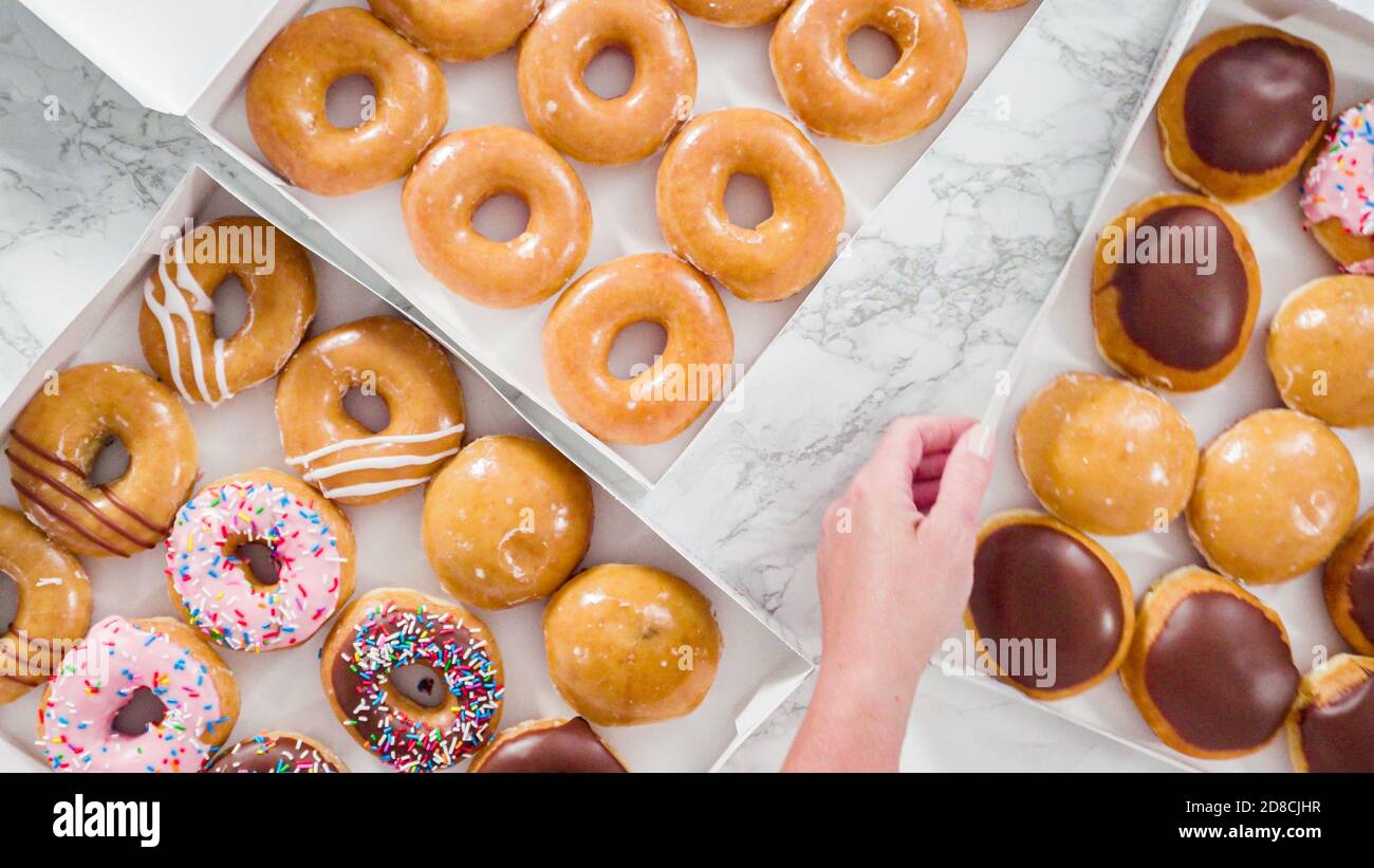 Flat lay. Variety of storebought doughnuts in a white paper box Stock
