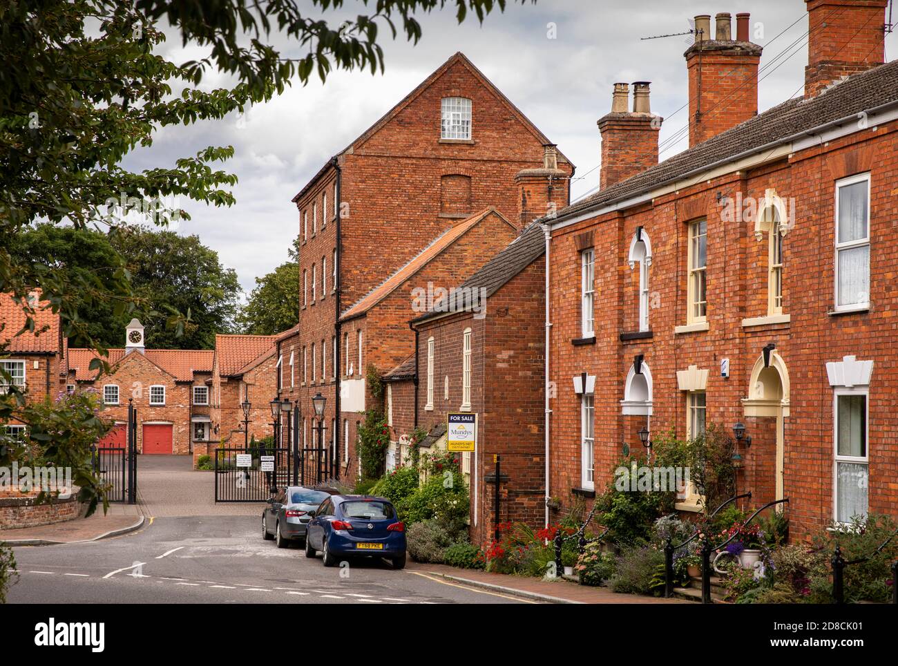 UK, England, Lincolnshire Wolds, Market Rasen, George Street, brick built houses beside old mill over River Rase and Church Mill Close development Stock Photo