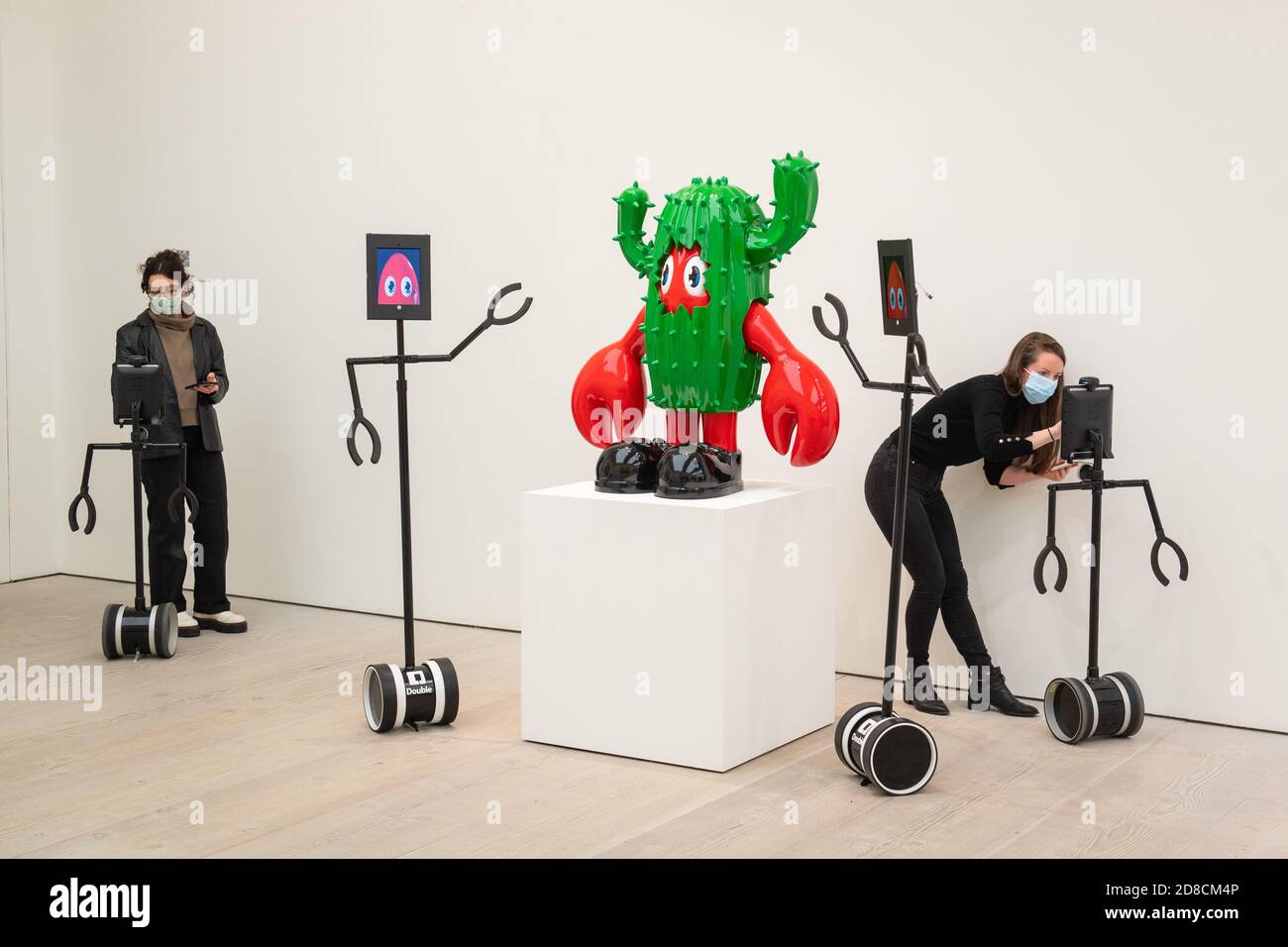 Gallery staff set up remote controlled robots, which can be used to view artworks remotely at a press preview of 'Philip Colbert: Lobsteropolis' exhibition at the Saatchi Gallery in London, which offers audiences the chance to view artworks in situ, or via robots from the comfort of their own home. Stock Photo