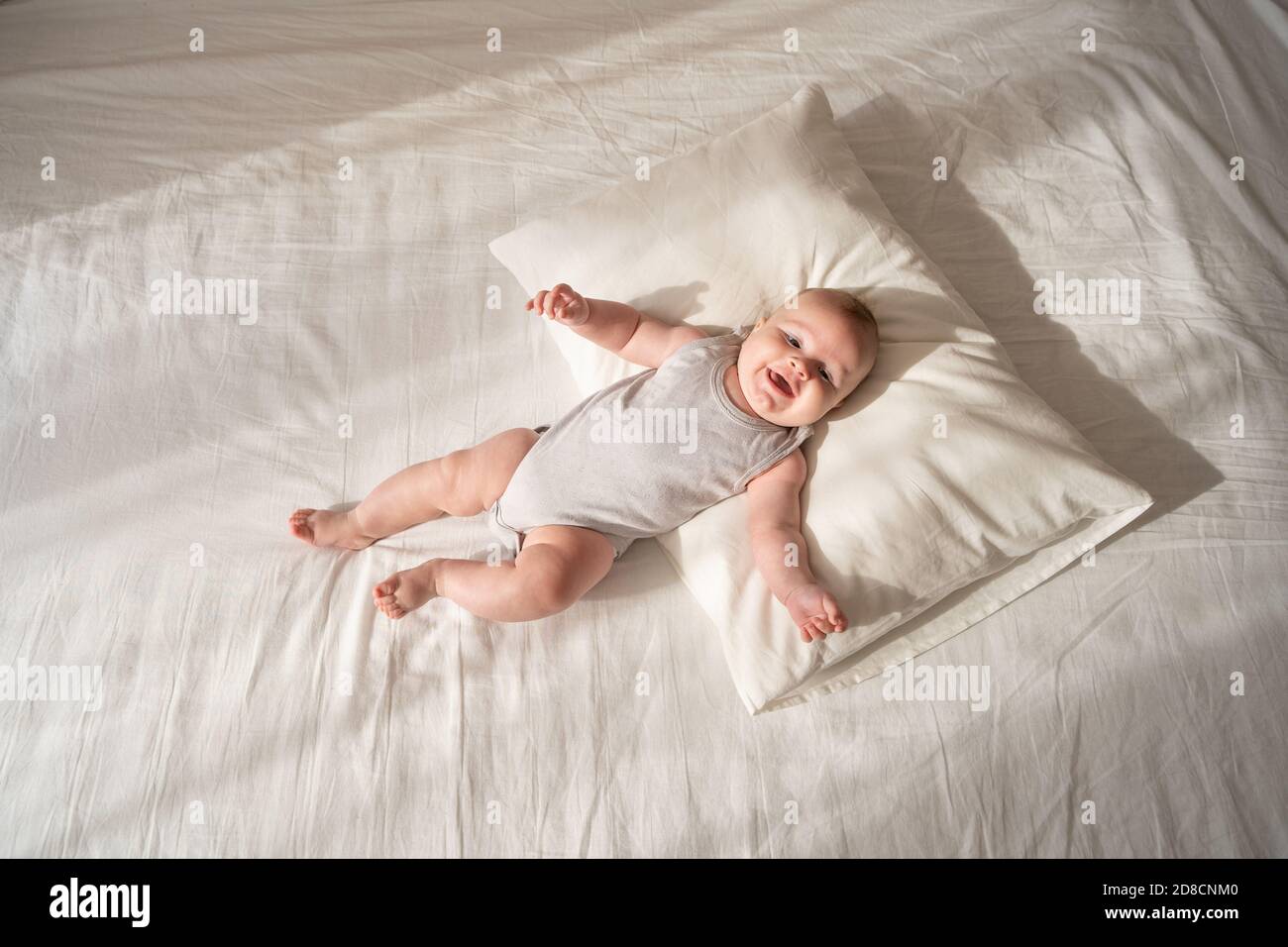Three month old baby lies on a white bed on a pillow Stock Photo Alamy