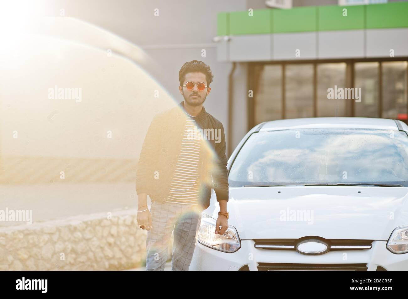 South asian man or indian male wear red eyeglasses stand near his white
