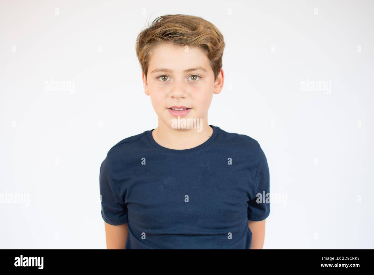 Photo of adorable young happy boy looking at camera over white ...