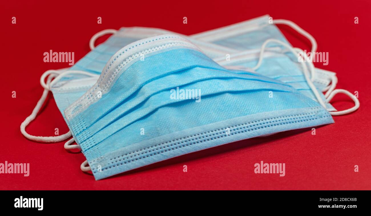 Disposable breathing masks isolated against a red background Stock Photo