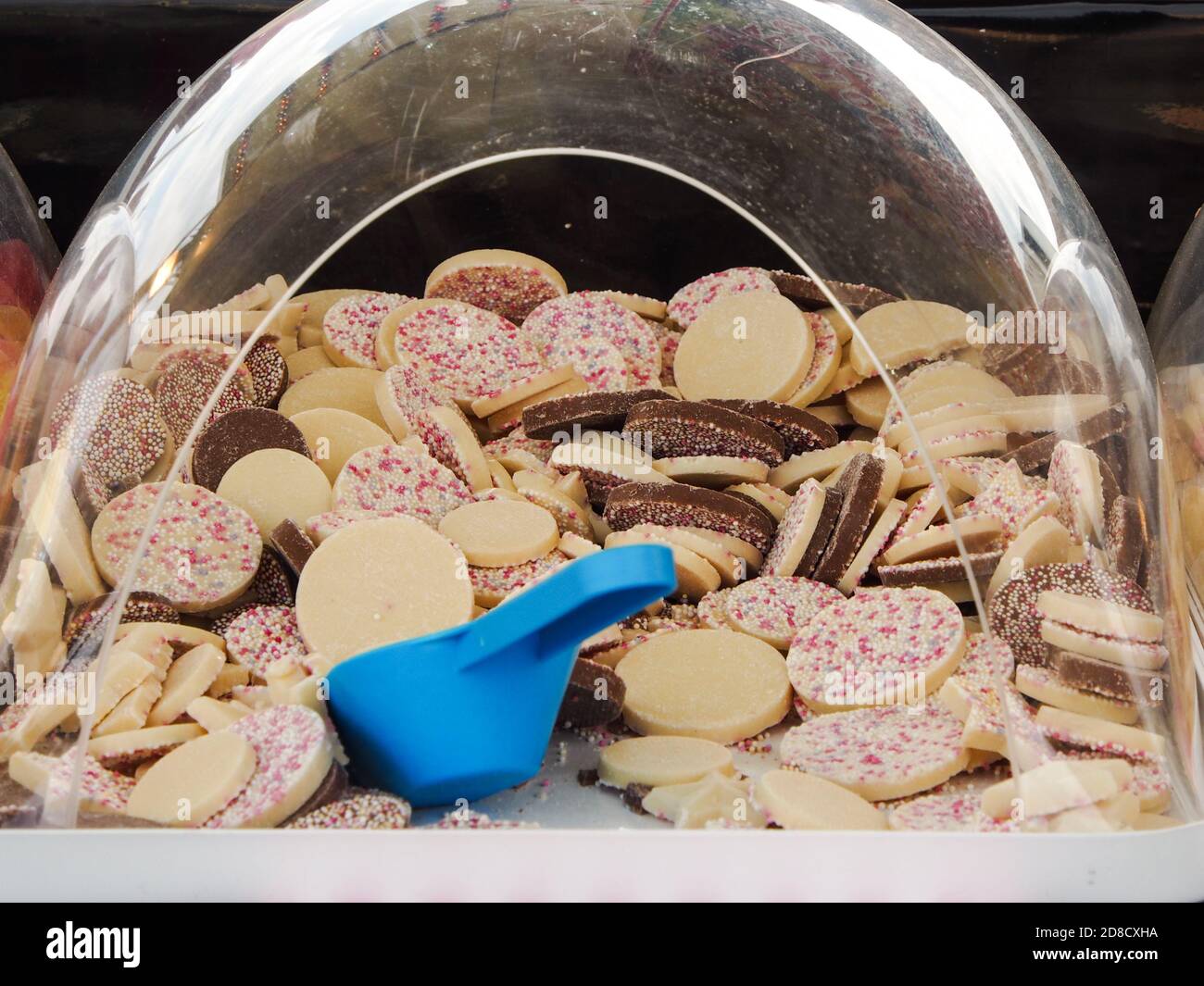 White chocolate candy buttons with a scoop at a pick n mix store Stock Photo