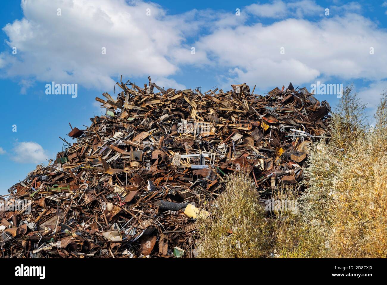 scrap metal heap at recycling junkyard against blue sky Stock Photo