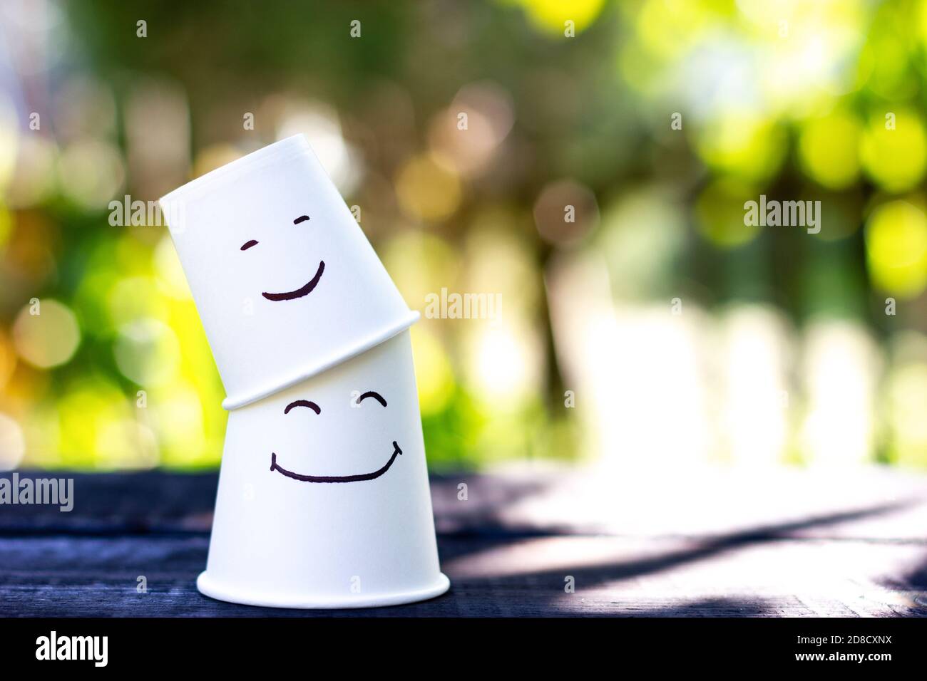 Two glasses with happy faces. Symbolism of the relationship between parents and children. Father's day, mother's day Stock Photo