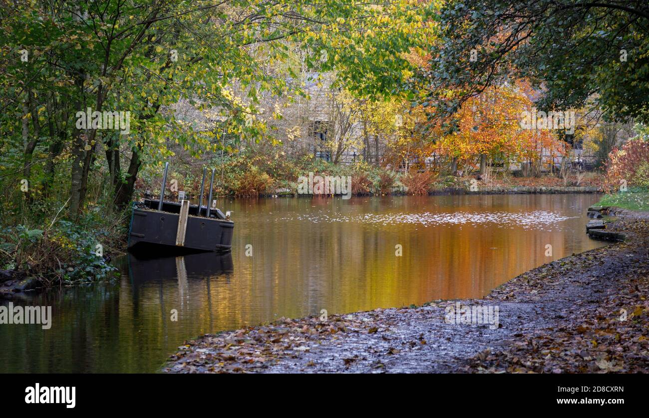 Autumn colours and barge on the Huddersfield Narrow Canal Uppermill to Dobcross section, Saddleworth, Oldham, England, UK Stock Photo