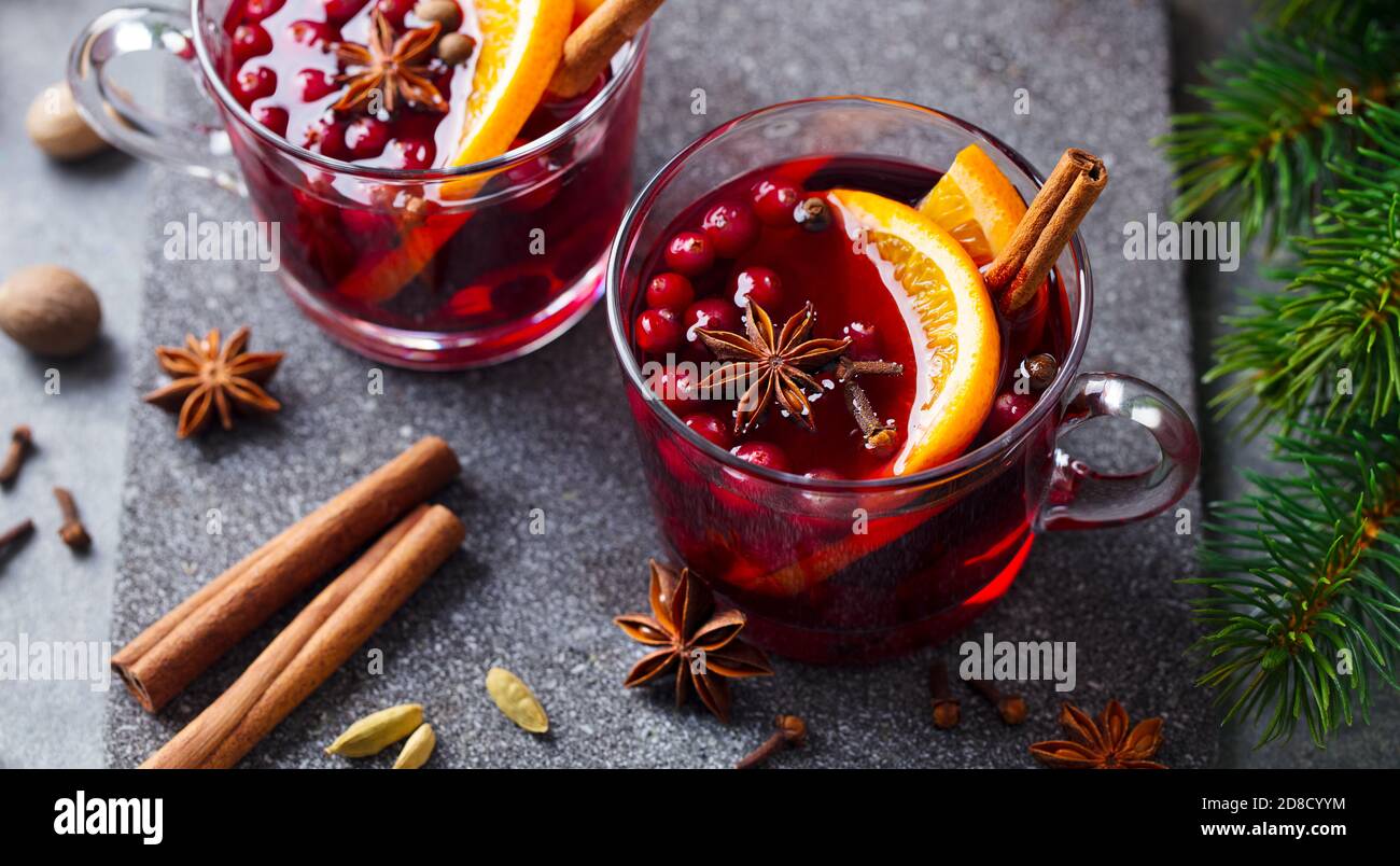Mulled red wine with spices. Christmas decoration. Grey stone background. Close up. Stock Photo