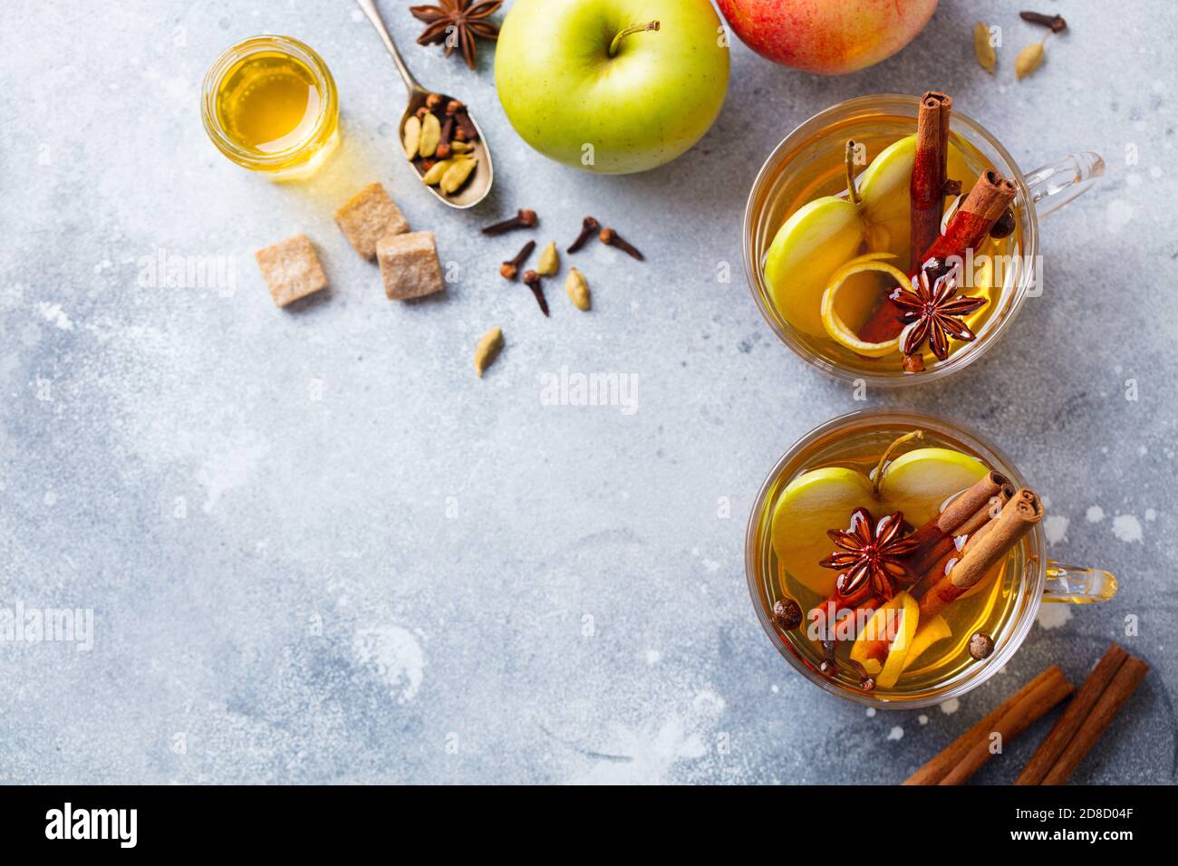 Apple mulled cider with spices in glass cup. Grey stone background. Copy spase. Top view. Stock Photo