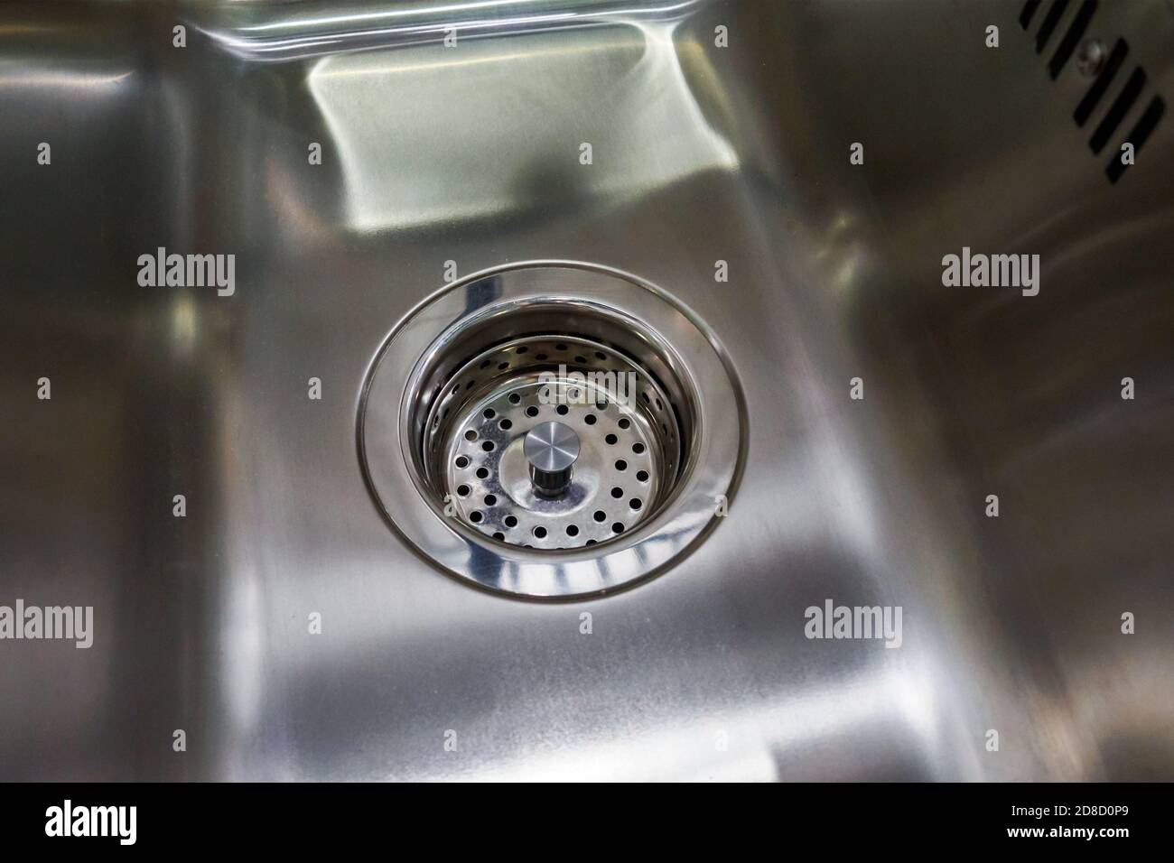 empty and dry metal kitchen sink with grill on drain Stock Photo
